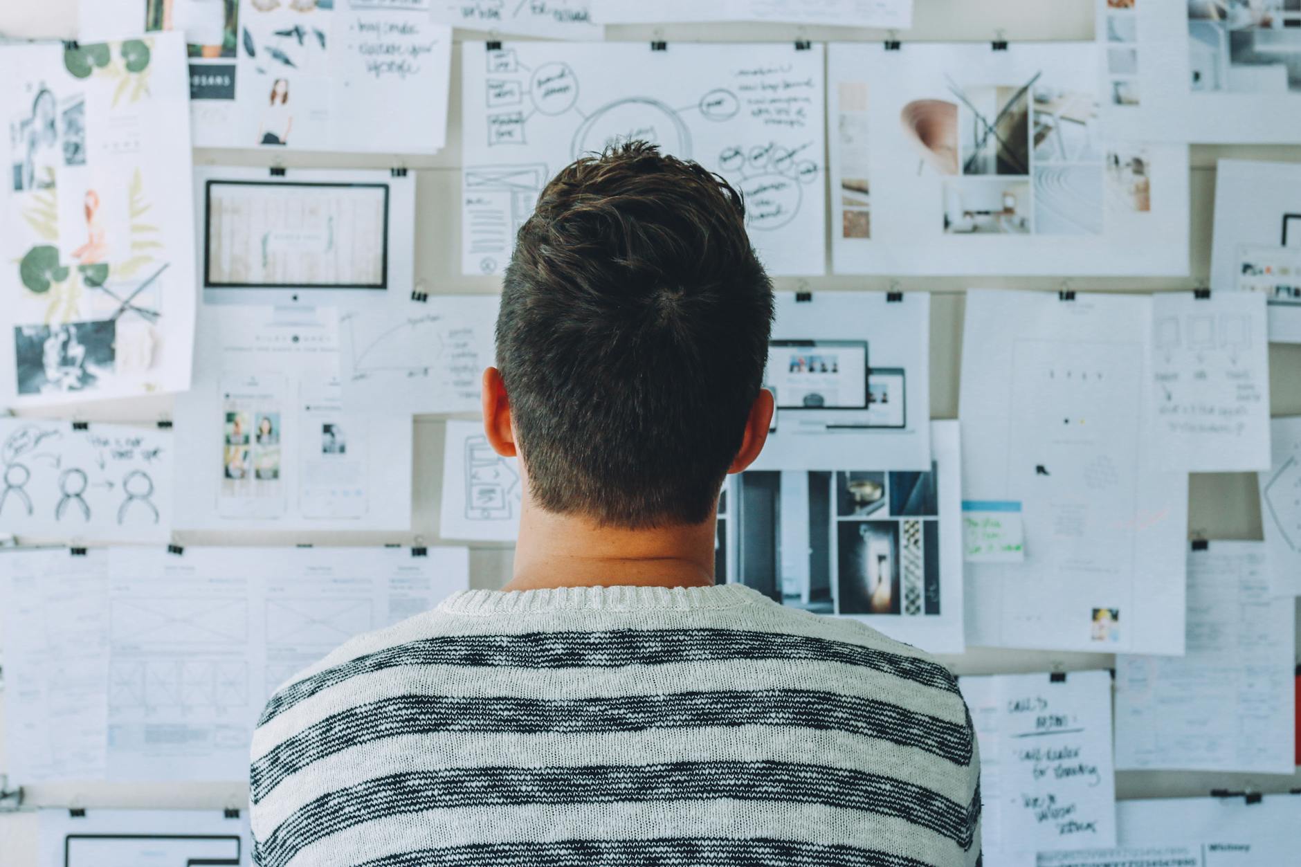man looking at charts taped to wall