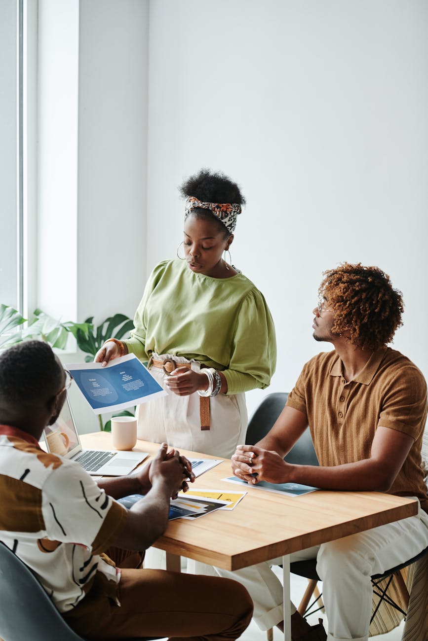 Picture of three people meeting. Leaders meet with followers to review goals and progress.